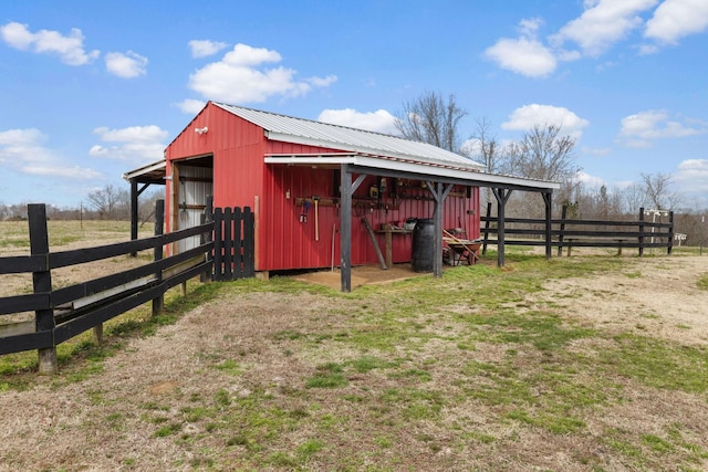view of outdoor structure with fence, an outbuilding, and an exterior structure