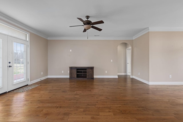 unfurnished living room featuring baseboards, ornamental molding, arched walkways, and ceiling fan