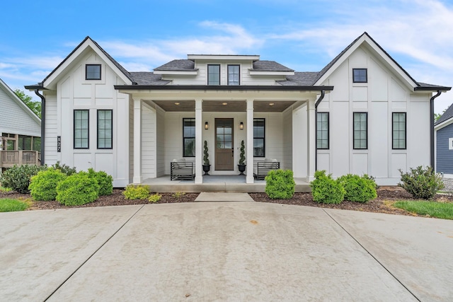 view of front of home with a porch, board and batten siding, and a shingled roof