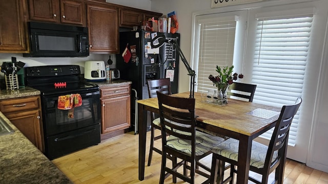 kitchen featuring light wood-type flooring and black appliances