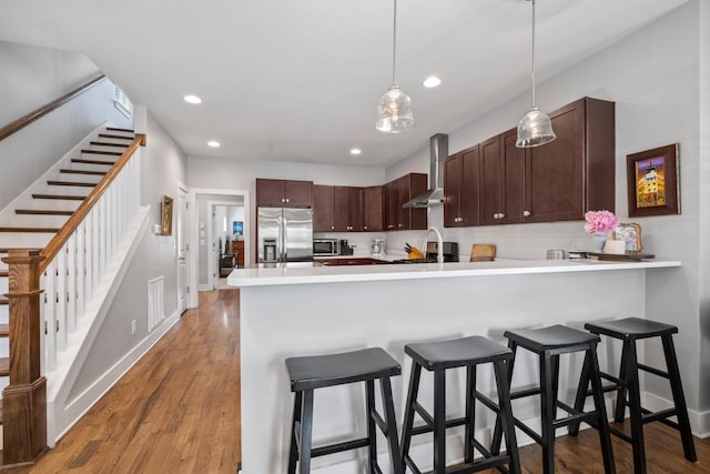 5604 Kentucky Ave, Nashville, TN 37209 - kitchen with light wood-style floors, wall chimney exhaust hood, light countertops, a peninsula, and stainless steel refrigerator with ice dispenser