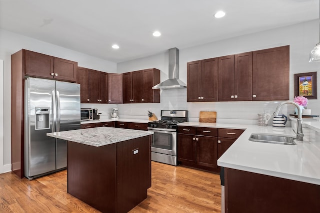 5604 Kentucky Ave, Nashville, TN 37209 - kitchen with light wood-style floors, wall chimney exhaust hood, appliances with stainless steel finishes, and a sink