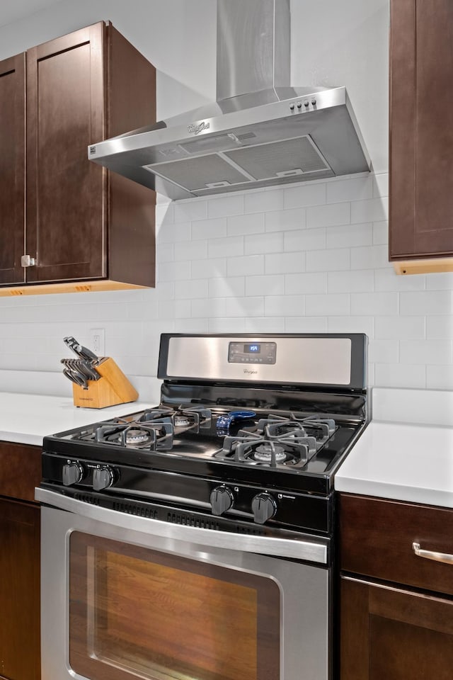 5604 Kentucky Ave, Nashville, TN 37209 - kitchen featuring light countertops, gas stove, dark brown cabinetry, and wall chimney range hood