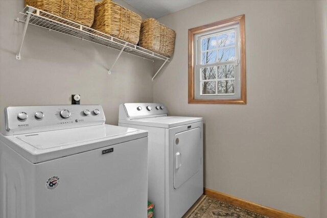 washroom with washing machine and clothes dryer, laundry area, and baseboards