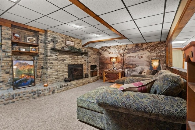 living room with a paneled ceiling, carpet flooring, and a brick fireplace