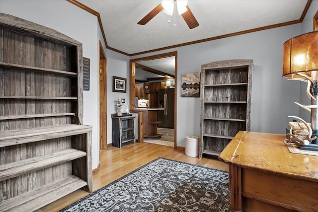 office area featuring a ceiling fan, light wood-style flooring, and crown molding