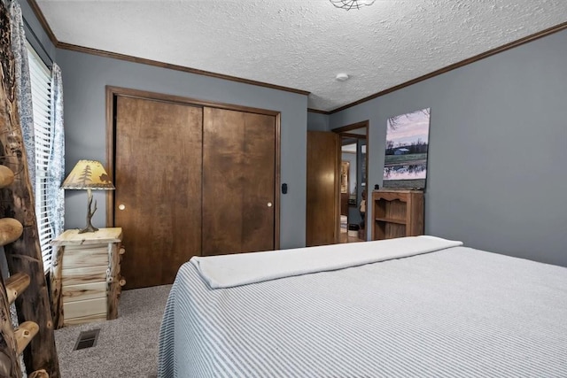 carpeted bedroom featuring a closet, crown molding, and visible vents