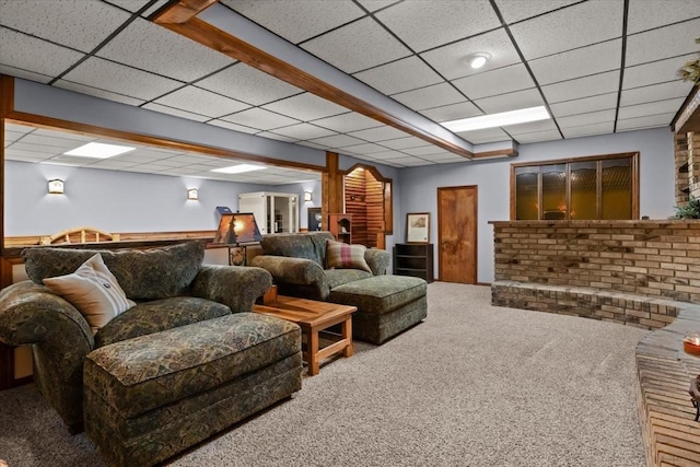 living room featuring carpet flooring and a drop ceiling