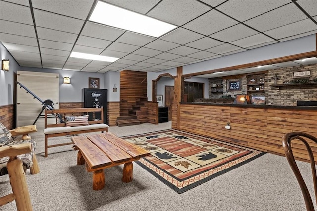 living room with wood walls, a wainscoted wall, and carpet flooring