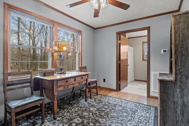 office area with crown molding, a ceiling fan, wood finished floors, baseboards, and visible vents