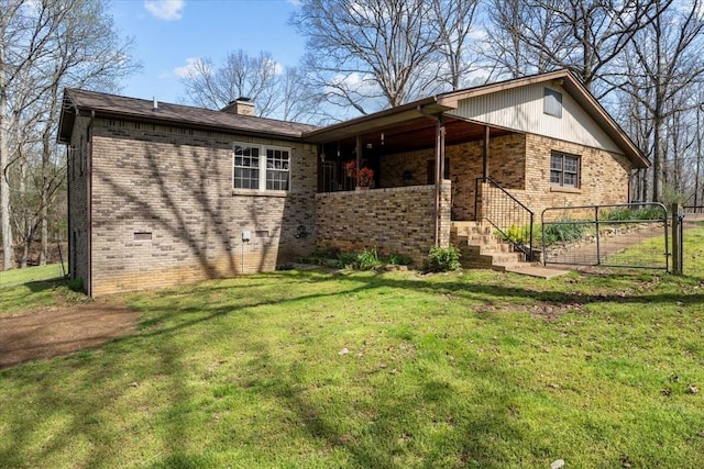 exterior space with brick siding, a lawn, a porch, and a chimney