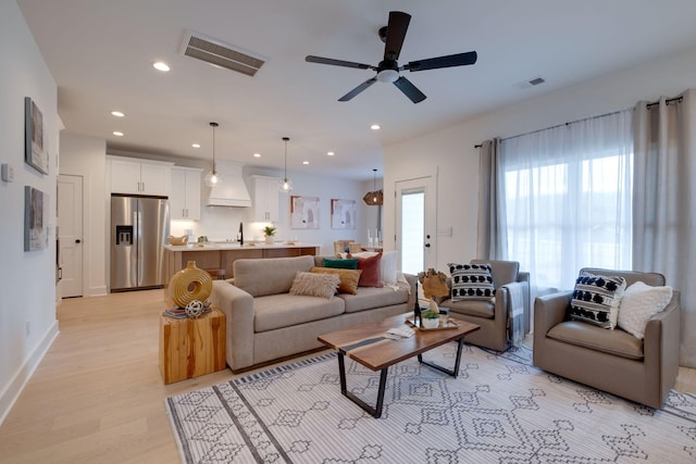 living room with recessed lighting, light wood-type flooring, visible vents, and ceiling fan
