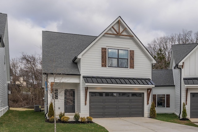 view of front of house with a garage, driveway, metal roof, a standing seam roof, and roof with shingles