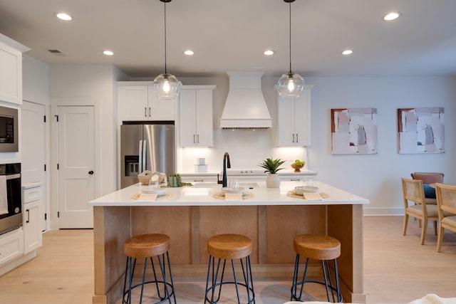 kitchen with premium range hood, light wood finished floors, a kitchen breakfast bar, and stainless steel fridge with ice dispenser