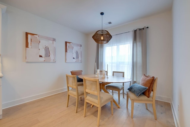 dining room with baseboards, visible vents, and light wood-type flooring