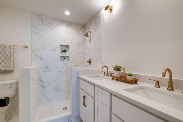 bathroom featuring a marble finish shower, a sink, marble finish floor, and toilet