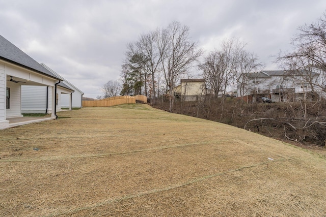 view of yard with a ceiling fan and fence