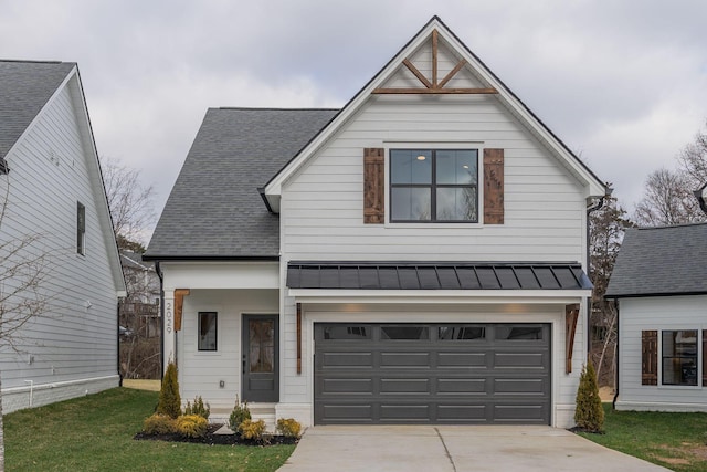 view of front of property with an attached garage, driveway, a standing seam roof, and metal roof