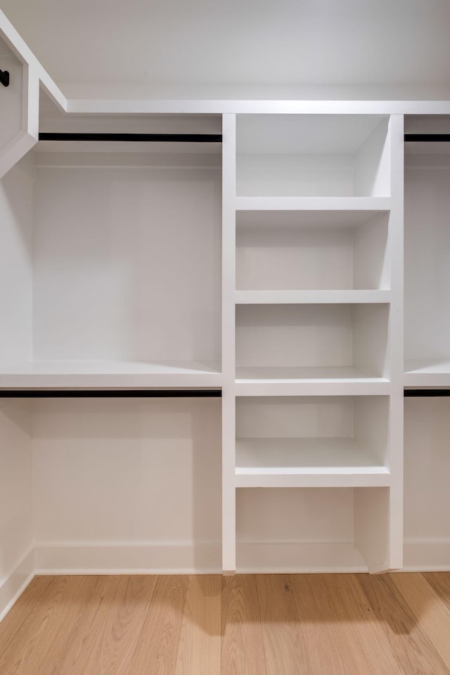 walk in closet with wood finished floors