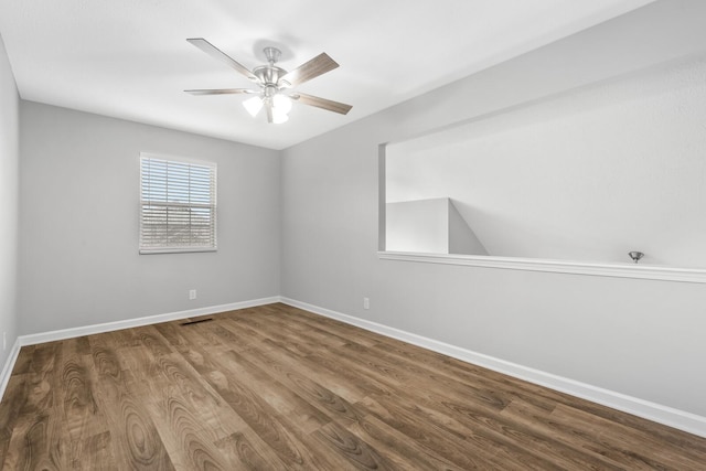 empty room featuring baseboards, a ceiling fan, and wood finished floors