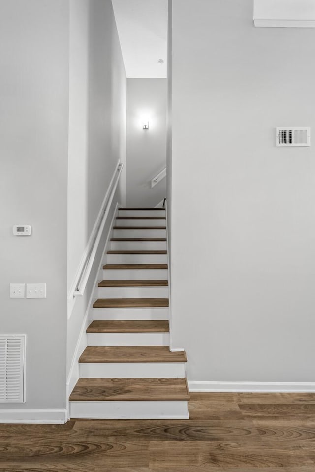 stairs with wood finished floors and baseboards