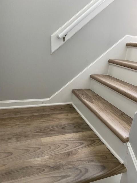 staircase with wood finished floors and baseboards