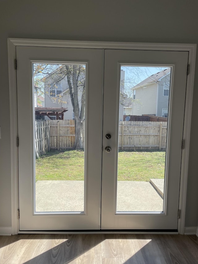 doorway to outside featuring wood finished floors and baseboards