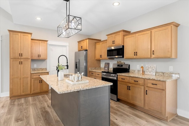 kitchen with a notable chandelier, light wood finished floors, stainless steel appliances, and a center island with sink