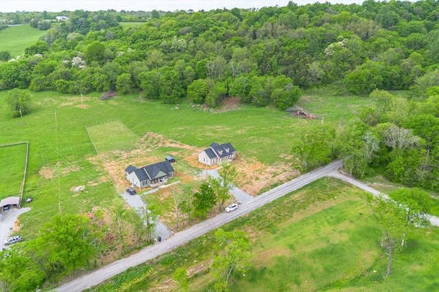 aerial view featuring a wooded view and a rural view