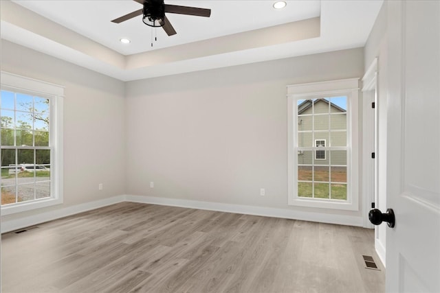empty room featuring baseboards, a ceiling fan, light wood-style floors, and visible vents