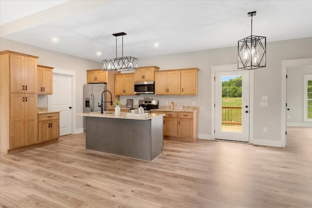kitchen with light brown cabinets, baseboards, appliances with stainless steel finishes, and light wood-style floors