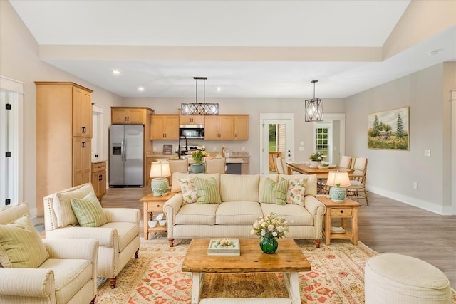 living area with recessed lighting, baseboards, and light wood-type flooring