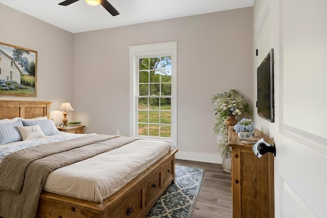 bedroom with wood finished floors, baseboards, and ceiling fan