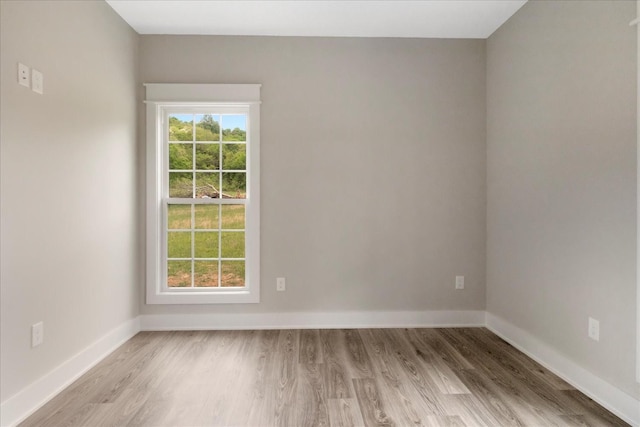 empty room featuring light wood finished floors and baseboards