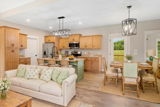 living area featuring a notable chandelier, light wood finished floors, and recessed lighting