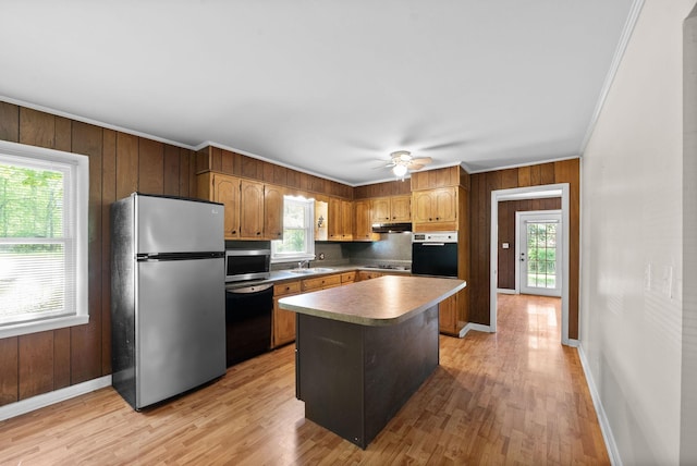 kitchen with under cabinet range hood, a wealth of natural light, stainless steel appliances, and baseboards