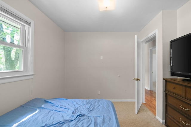 bedroom featuring baseboards and light carpet