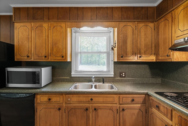 kitchen featuring a sink, under cabinet range hood, black appliances, brown cabinetry, and backsplash