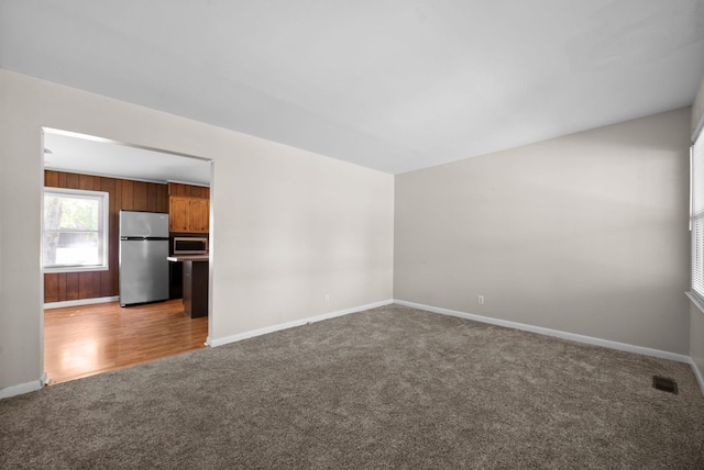 spare room featuring visible vents, baseboards, and light colored carpet