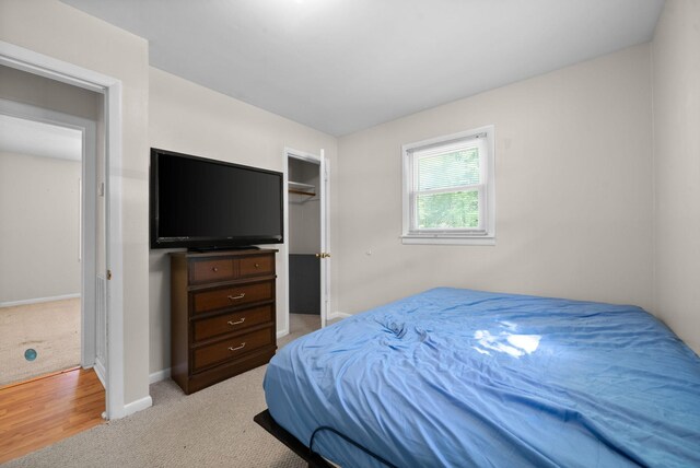 bedroom with baseboards and light colored carpet