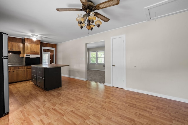 kitchen featuring a ceiling fan, oven, a center island, and light wood finished floors