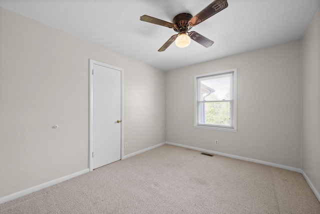unfurnished room with visible vents, a ceiling fan, baseboards, and light carpet