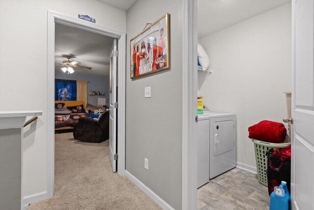 clothes washing area featuring washing machine and dryer, a ceiling fan, baseboards, and laundry area