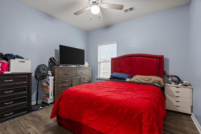 bedroom with baseboards, visible vents, dark wood-style floors, and ceiling fan