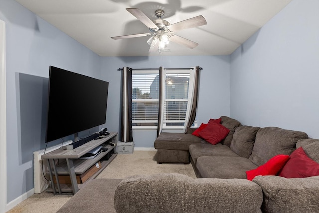 living area featuring a ceiling fan, baseboards, and carpet