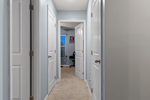 corridor with light carpet and baseboards