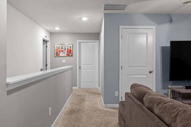 hall featuring light carpet, baseboards, visible vents, and recessed lighting