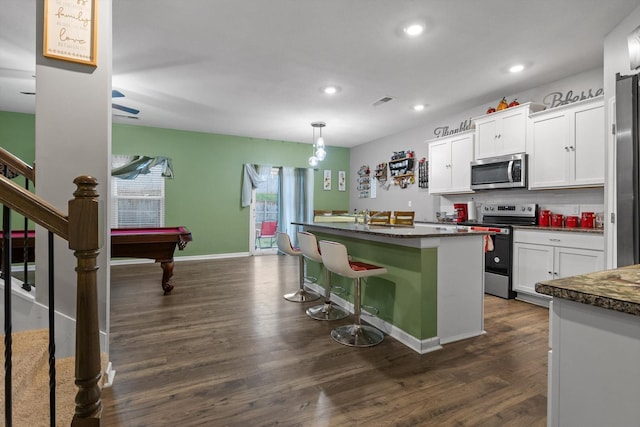 kitchen with white cabinets, stainless steel appliances, and dark wood-style floors