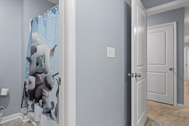 bathroom with baseboards and a shower with shower curtain