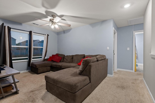 living room with attic access, baseboards, visible vents, light colored carpet, and a ceiling fan